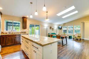 een keuken met een groot eiland en een woonkamer bij Puget Sound Single-Level Gem with Outdoor Fun! in Frederickson