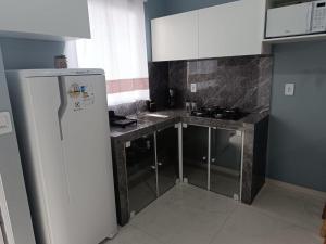 eine Küche mit einem weißen Kühlschrank und einem Herd in der Unterkunft Studios Próx. à Praia de São Miguel | 4,9 km Beto Carrero in Gravata