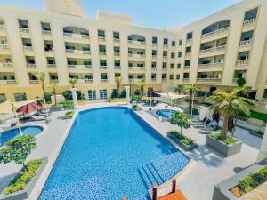 an empty pool in front of a large building at Stylish Furnsihed Apartments Opposite Five Hotel In JVC in Dubai