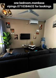 VipingoFuraha Homes的客厅配有黑色沙发和平面电视。