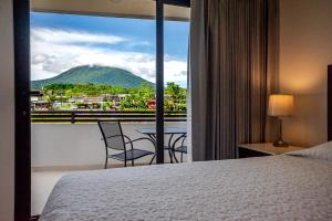 a bedroom with a bed and a view of a mountain at Hotel Arenal by Regina in Fortuna