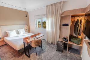 una habitación de hotel con una cama y un escritorio en Hôtel AKENA Chalons-en-Champagne, en Châlons-en-Champagne 50 fotos más