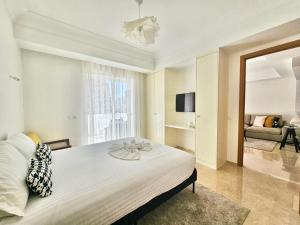 a bedroom with a large bed and a living room at CFC - Douceur et luminosité in Oulad Akkou +19 photos