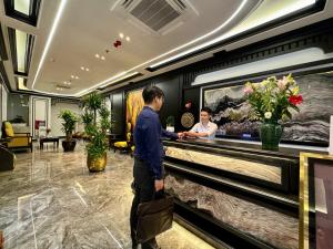 a man standing at a counter in a hotel lobby at Royal Hotel Hà Nội in Lưu Phái