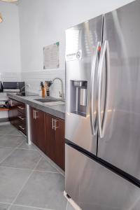 a stainless steel refrigerator in a kitchen at Hotel Arenal by Regina in Fortuna +36 photos