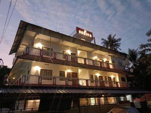 a large white building with a balcony on top of it at Godiva Homestay in Cochin