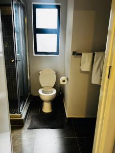 een kleine badkamer met een toilet en een raam bij The Nook in Gaborone +8 foto's