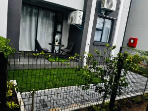 een veranda aan de voorzijde van een huis met een tafel en stoelen bij The Nook in Gaborone