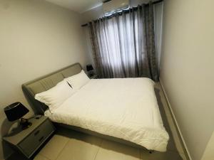 een bed in een kleine kamer met een raam bij The Nook in Gaborone