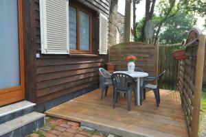 eine Terrasse mit Tisch und Stühlen auf einem Deck in der Unterkunft Gîte Erziwezh in La Porte