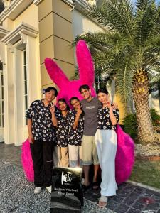 Un grupo de personas de pie frente a una carroza rosa. en hiii Aura Pool Villa Hotel Pattaya Central, en Pattaya central 207 fotos más