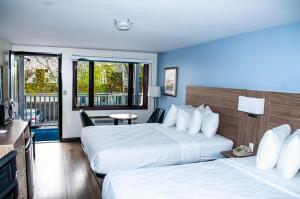 een hotelkamer met twee bedden en een balkon bij USA Inn in Wells