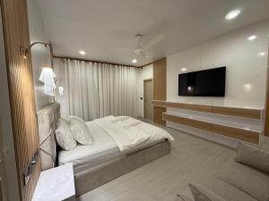 a hotel room with a bed and a flat screen tv at Old Town Beach in Gaafaru