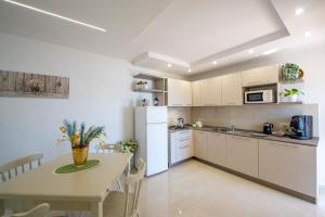 a kitchen with white cabinets and a table and a dining room at La Dimora del Bacchiss in Amalfi +9 photos