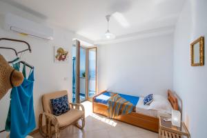a bedroom with a bed and a chair at La Dimora del Bacchiss in Amalfi