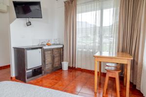 Habitación con escritorio, TV y cama. en Hotel Arenal by Regina, en Fortuna