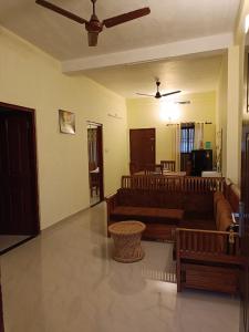 a living room with couches and a ceiling fan at Godiva Homestay in Cochin
