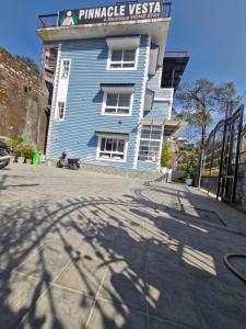 a blue building with a sign on top of it at Pinnacle Vesta Homestay in Mussoorie