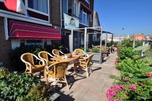 a patio with a table and chairs and flowers at Pension & Spa de Watertoren in Zandvoort