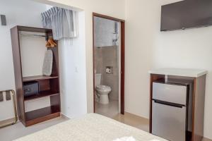 Un pequeño baño con inodoro y nevera. en Hotel Arenal by Regina, en Fortuna 49 fotos más