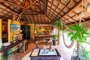 a living room with a table and some plants at Tua Pousada Boutique Tatuamunha, Rota Ecológica dos Milagres, Porto de Pedras, Alagoas in Tatuamunha
