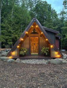 a cabin with a porch with lights on it at Trekker, Treehouses cabins and lodge rooms in Lake George