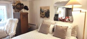 een slaapkamer met een bed met kussens en een spiegel bij PARIS AUTHENTIC HOUSE Métro Line 14 Station Hôpital Bicêtre, RER B Gentilly in Parijs