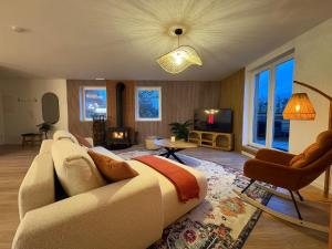 een woonkamer met een bank en een tv bij Le lofty in Stoumont