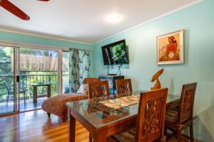 een eetkamer met een tafel, stoelen en een televisie bij Private Balcony! Lahaina Retreat with Ocean Access in Honokowai