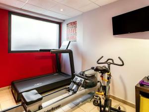 - une salle de sport avec un tapis de course et un vélo dans l'établissement Aparthotel Adagio Paris Malakoff Chatillon, à Malakoff