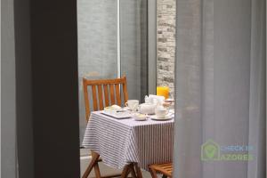 een tafel met kopjes en borden erop bij Cantinho da Bea I in Angra do Heroísmo