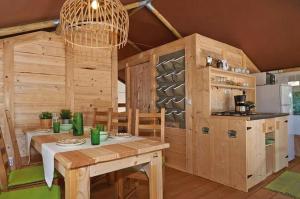 a dining room with a table and a kitchen at Camping Village Lago Maggiore in Dormelletto