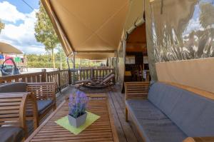 a porch with chairs and a table and a couch at Camping Village Lago Maggiore in Dormelletto