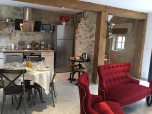 eine Küche mit einem Tisch und roten Stühlen in der Küche in der Unterkunft Casa La Palma II La Courmellette in Soissons