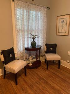 a living room with two chairs and a table and a window at Cozy Home close to Downtown in San Antonio