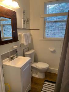 a white bathroom with a toilet and a sink at Cozy Home close to Downtown in San Antonio