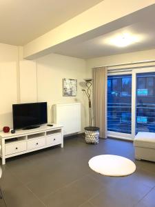 a living room with a flat screen tv and a couch at Stijlvol appartement in hartje Oostende vlak bij het strand en de winkelstraat - 6p in Ostend