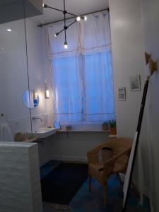 ナントにあるSuite Pommerayeのバスルーム(バスタブ、シンク付)、窓が備わります。