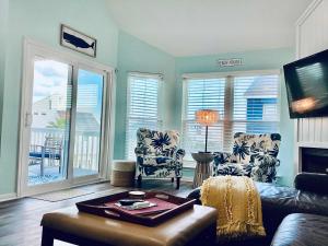a living room with a couch and chairs and windows at Saltwater Solace For 8 in Galveston