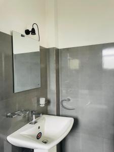 een badkamer met een witte wastafel en een spiegel bij Villa C & C Thalpe in Talpe