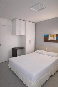 a bedroom with a large white bed and white cabinets at Gran Lençóis Flat Residence 2 suítes com sala e cooktop in Barreirinhas