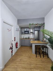 cocina abierta con mesa y nevera en VOLPI MAZZO, en Madrid