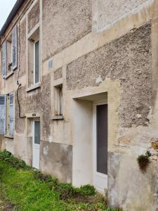 ein altes Gebäude mit einer Tür und einem Fenster in der Unterkunft Vert Bocage Briard - Freedomus Marne-la-Vallée in Esbly