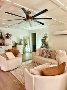 un soggiorno con due divani e un ventilatore a soffitto di The Wing - luxurious king suite tiny studio home! a Eureka Springs