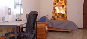 a bedroom with a bed and a desk with a desk at Hotel y Cabañas El Taxho in El Porvenir