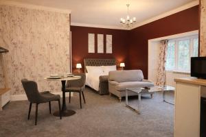 een hotelkamer met een bed, een tafel en stoelen bij Rossal House Apartments, Inverness, Highlands in Inverness +10 foto's