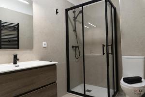 un bagno con doccia, lavandino e WC di Malasaña Urban Rooms a Madrid Altre 32 foto