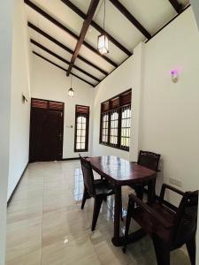 ein Esszimmer mit einem Holztisch und Stühlen in der Unterkunft The Kadupul Villa in Ahungalla