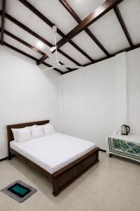 ein weißes Schlafzimmer mit einem großen Bett und einer Decke in der Unterkunft The Kadupul Villa in Ahungalla