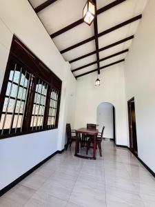 ein Esszimmer mit einem Tisch und Stühlen in einem Raum in der Unterkunft The Kadupul Villa in Ahungalla + 8 Fotos